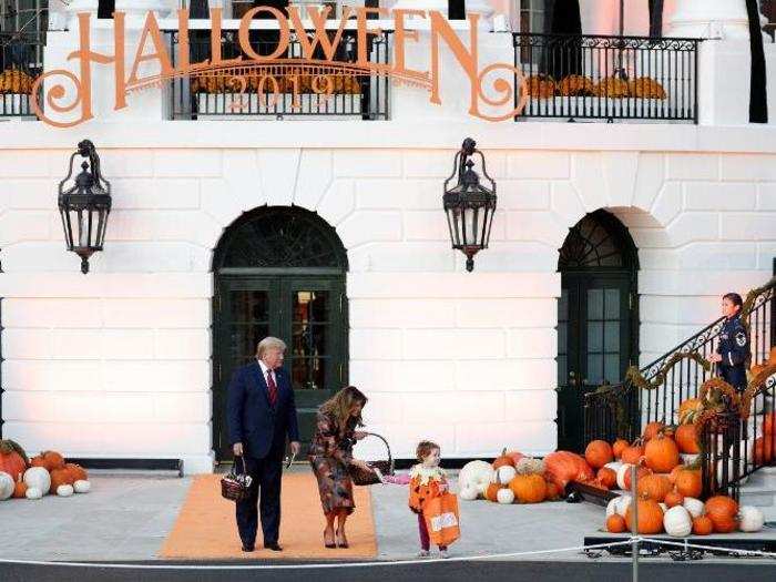 Another child dressed as a pumpkin seems to blend in with the display.