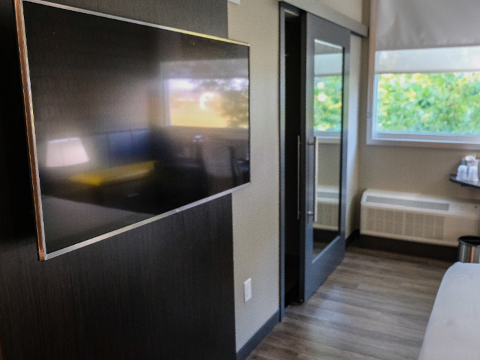 A flat-screen TV was mounted on the wall directly in front of the bed.