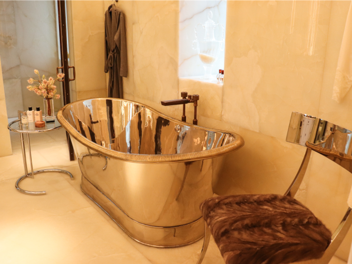 A glossy, freestanding soaking tub is the focal point of the glamorous bathroom.