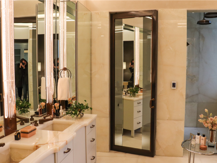 ... and across from that is the marble-clad master bathroom, which features dual vanities and a walk-in rain shower.