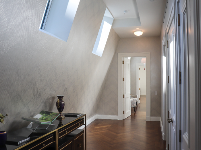 The hallway leading to the bedrooms is illuminated by skylights.