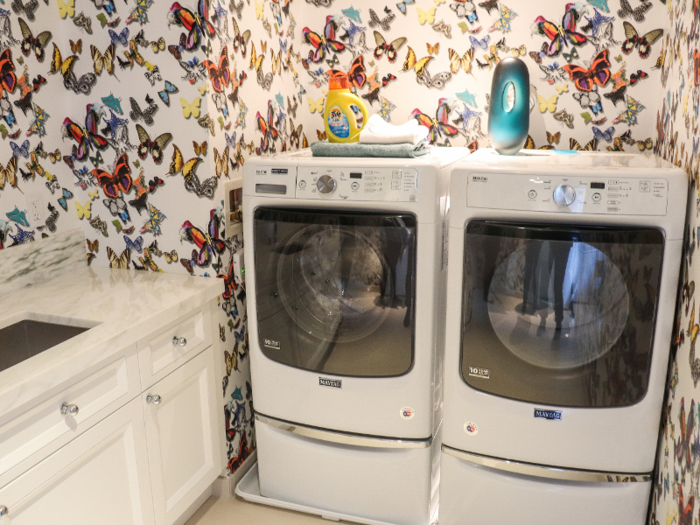 Just off the kitchen is a laundry room decorated with cheerful butterfly wallpaper.