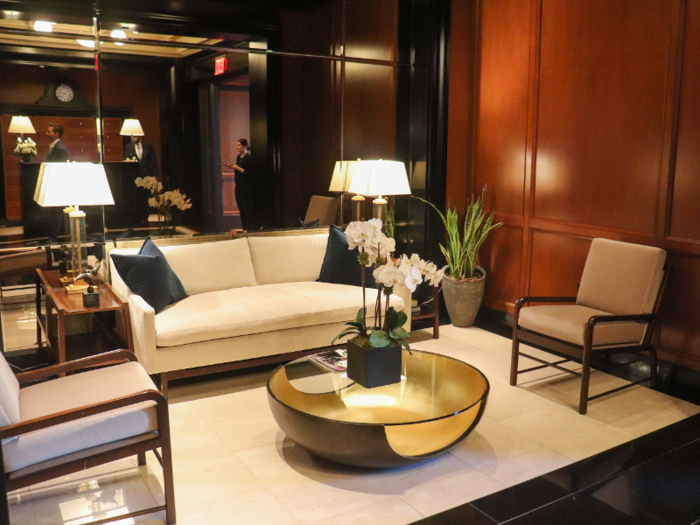 The residential lobby is intimate, with a small seating area ...