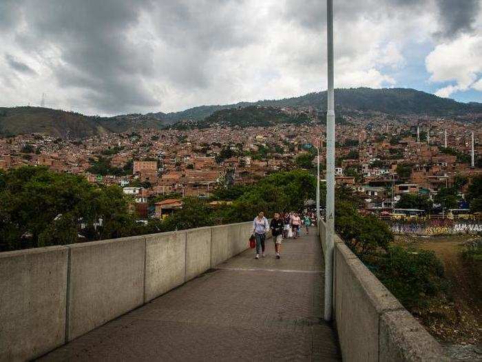 Access to the metro stations comes through walkways that allow people to cross over the Medellín River.