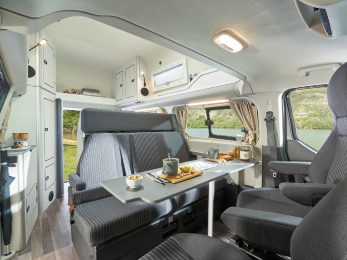 The foldout table can fit five people. The forward-facing bench can seat three, while the driver and front passenger seats can swivel to face the rear. For outdoor dining, there’s also a foldout table with two chairs and a retractable awning.