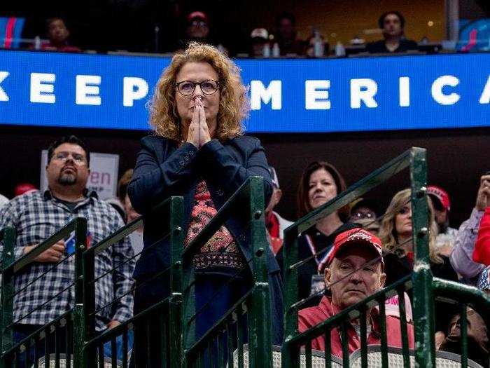 Here, a woman in the audience held her hands together as she listened to Trump speak.