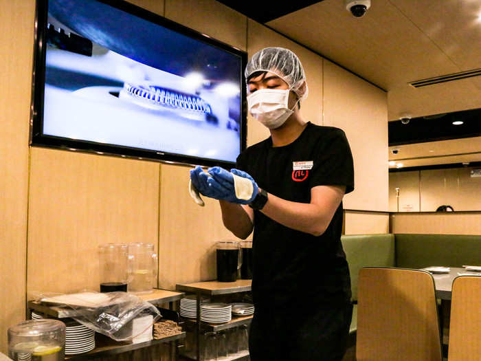 A masked server with a tray of dough pulled up to my table. Loud music began to play.