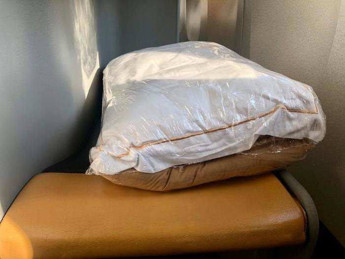 There was an ottoman in front of the seat, which served as the end of the bed once a passenger lays the seat flat. There was a shrink-wrapped pillow and comforter on the ottoman.