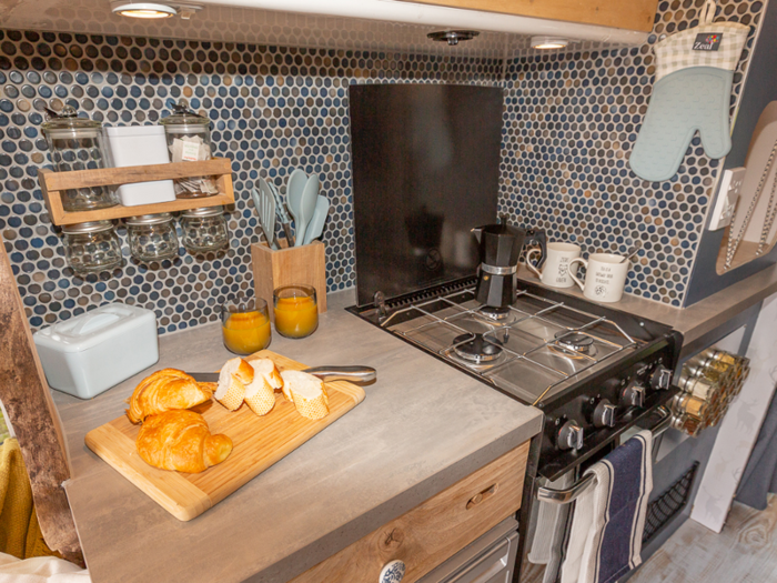 The kitchen includes a three-burner stove and gas oven.