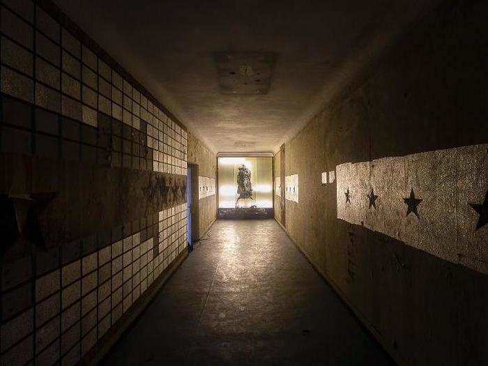 At the end of this dim hallway stands an illuminated image of Joseph Stalin carrying a child.