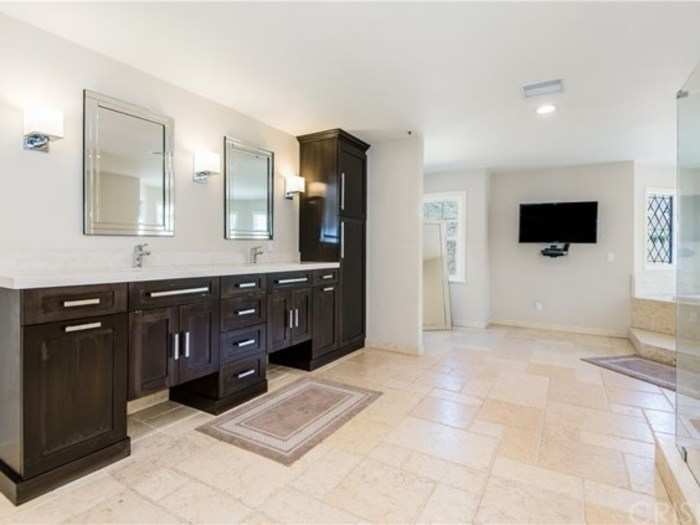 The double vanities provide lots of extra space and a TV ensures you won