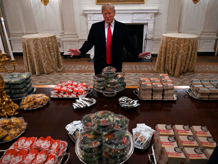 President Donald Trump serves fast food to the Clemson football team.