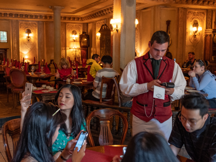 The male servers at Café Pushkin wore black pants with crisp white shirts, red vests, and long white aprons.