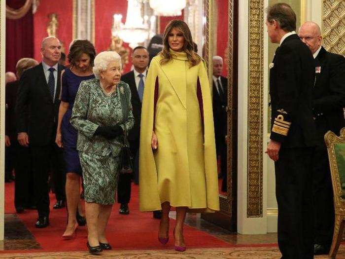 First Lady Melania Trump walks beside Queen Elizabeth II.