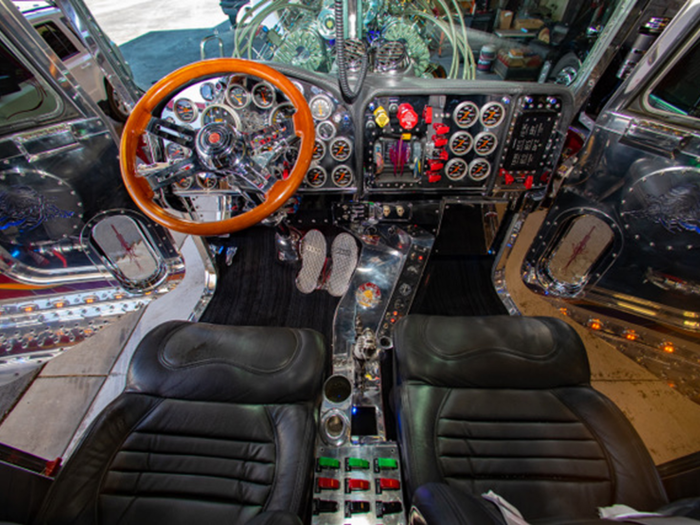 The interior is made up of leather that has been custom-stitched and a wood-rim steering wheel.