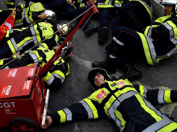 Firefighters lay on the ground to demonstrate. They