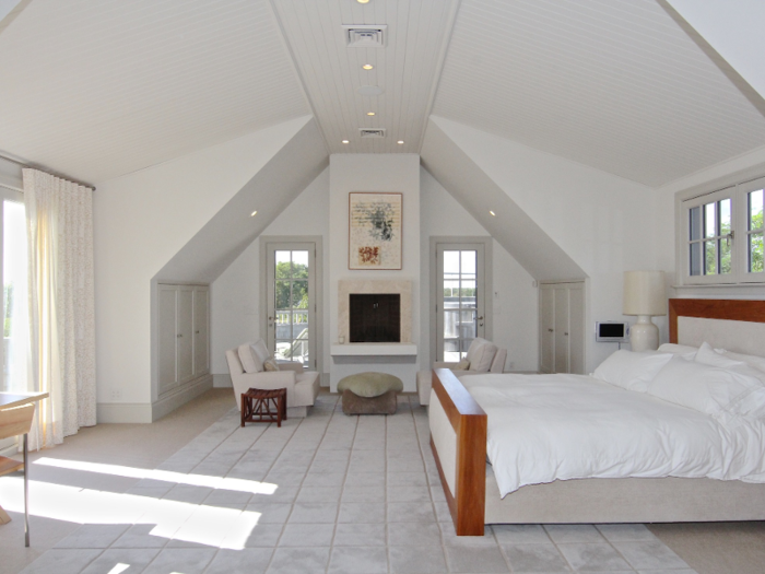 The master bedroom features high ceilings and glass doors that open up to the outdoors.