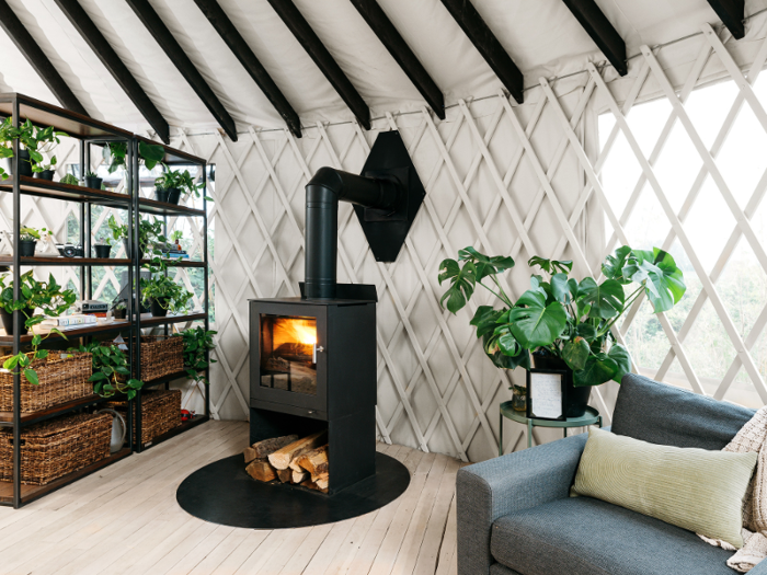 At the far end of the living room, there is a large wood-burning stove.