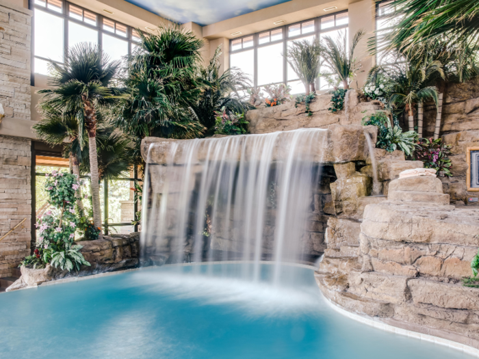 The tropical indoor swimming pool grotto has a tiki bar, hot tub, waterfall and a ceiling painted to look like the sky with fiber optics that light up to mimic constellations and shooting stars.