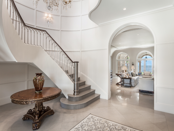 The mansion sits on a 62,000-square-foot waterfront lot. At the entrance of the home, residents and guests are greeted with a spacious foyer that boasts a custom-designed spiral staircase.