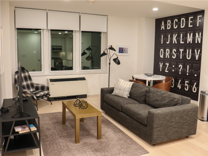 The living area was spacious for New York City. The modern furnishings included a sofa and coffee table, an armchair, a TV, and a small dining nook.