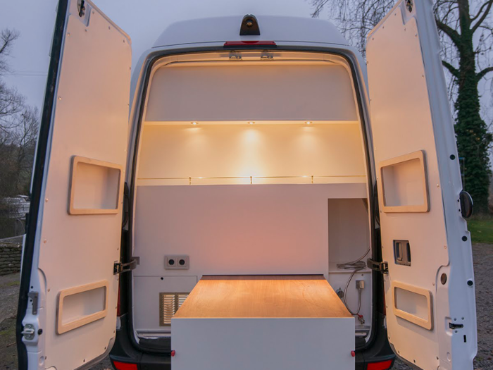 The rear door has storage units and a gallery-style shelf.