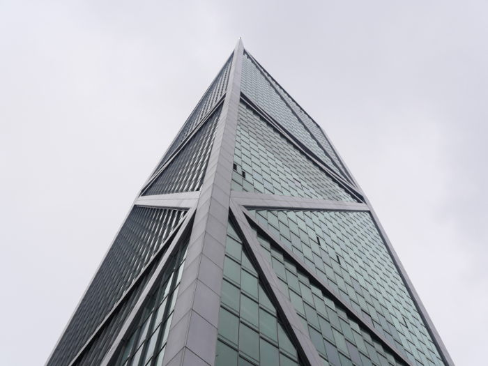 From the rooftop park, you can see a glass high-rise encased in white beams.