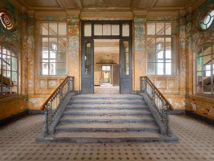 In this entryway, you can see the paint fading on the ornately designed walls.