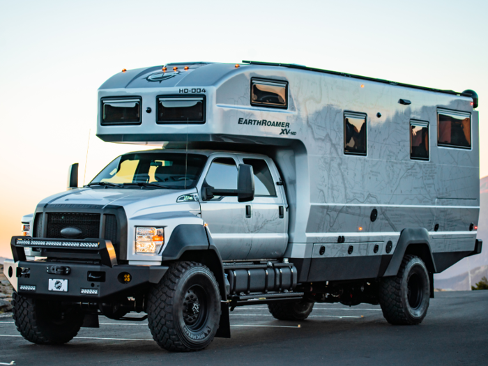 The exterior of the van includes a slide-out kitchen and retractable awning with dimmable LED lights.