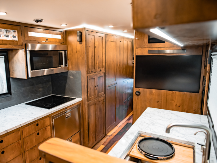 A television is embedded into the walls and cabinet to maximize the tiny home