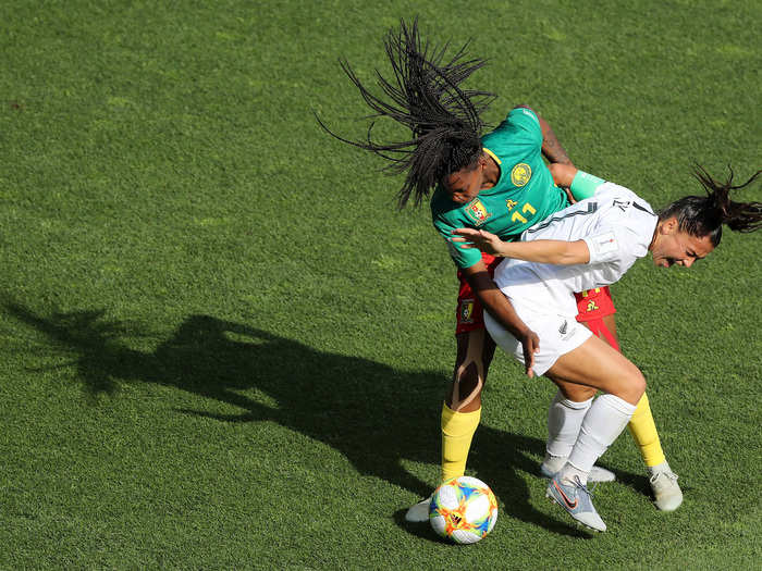 Ali Riley of New Zealand battles for possession with Aurelle Awona of Cameroon during their teams