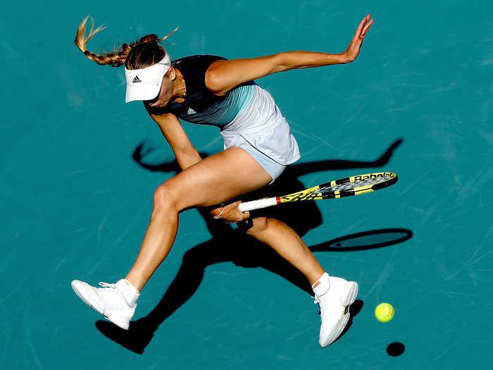 Caroline Wozniacki hits a ball between her legs while playing Monica Niculescu of Romania during the Miami Open in Miami Gardens, Florida.