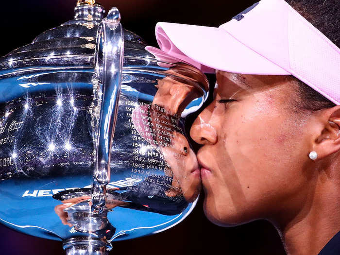 Naomi Osaka kisses the Daphne Akhurst Memorial Cup after defeating Petra Kvitova in the Women