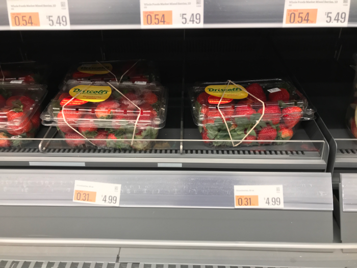 At this location, whole strawberries and large containers of yogurt were on the shelves.