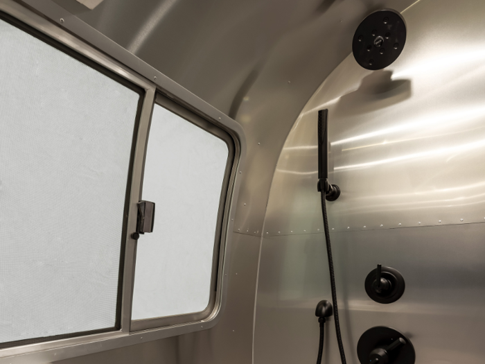 The shower includes a stainless steel shower pan and a duckboard.