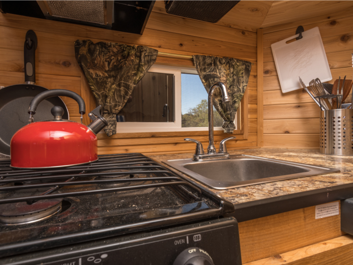 The kitchen has a three-burner range, an oven, and a refrigerator.