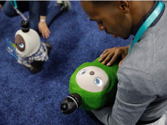 Here, a Lovot robot got a cuddle from an attendee.