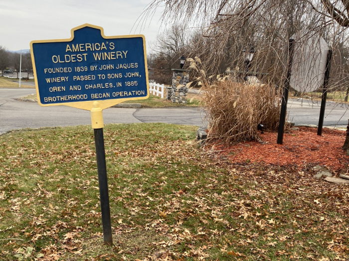 Marking the entrance to the winery is a blue and yellow New York historical marker that reads "America