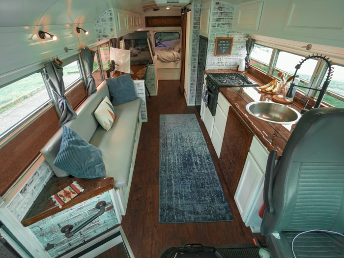 A table — seen as the wooden paneling under the sink in the photo below — pops out and can be used both inside and outside the bus.