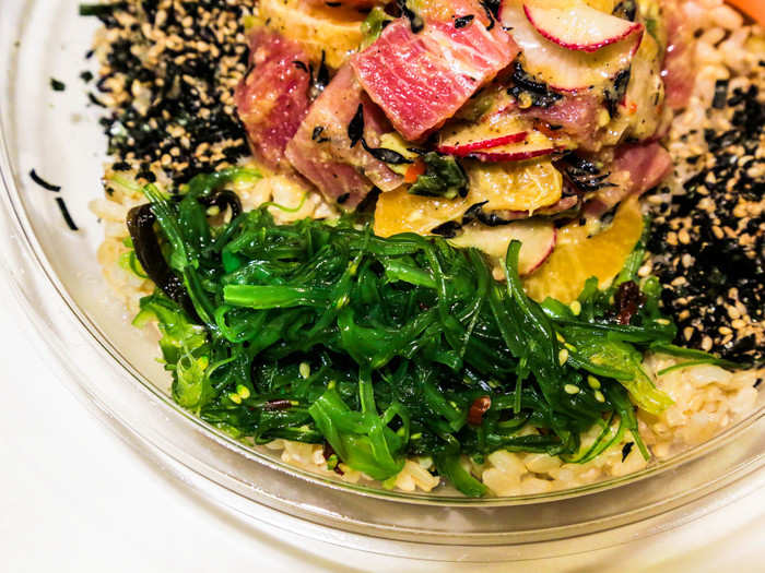 The bowl comes with a side of seaweed salad and a generous dash of furikake, a Japanese rice seasoning.