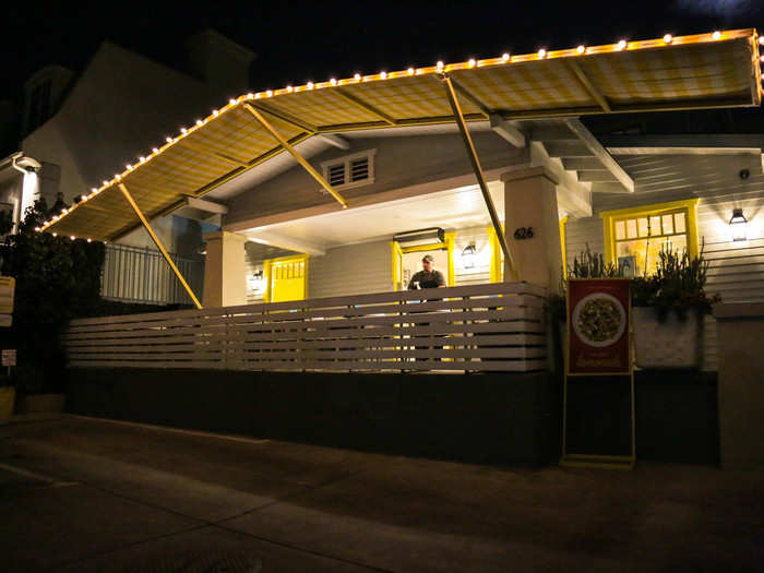 It was a cute, homey one-story house with outdoor seating and bright yellow trim.