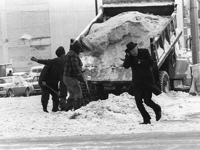 In Cleveland, the windchill dropped to -35 degrees Fahrenheit. Here, a man looks to be clutching his ear, while others try clear snow off the streets.