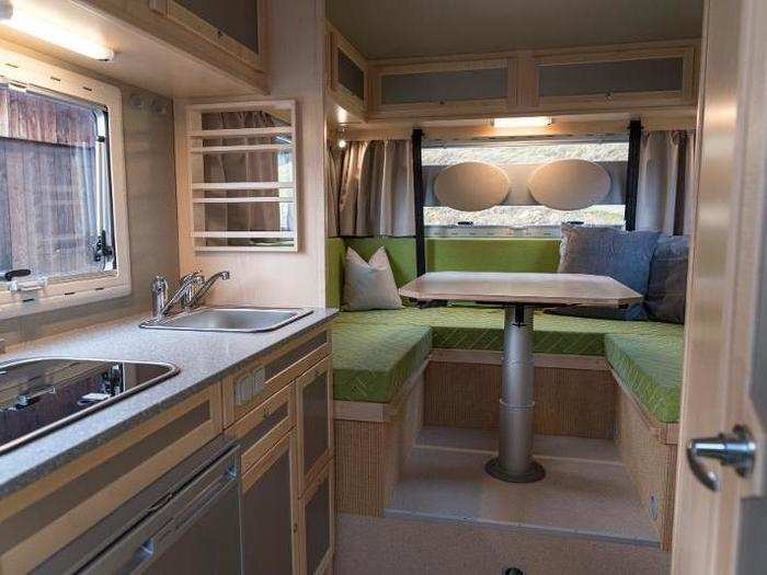 The interior of the campervan has multiple storage spaces, including cupboards and drawers.