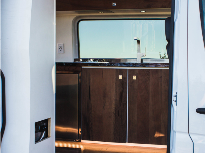 Custom components of the van include the cabinets, redwood finishes, and upholstery.