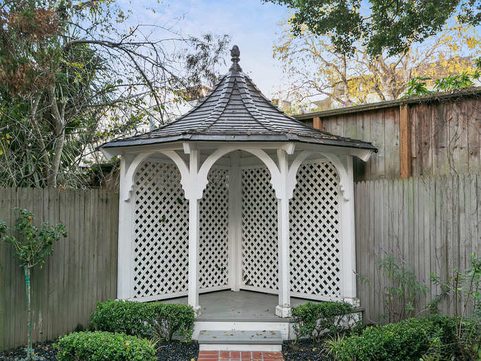 A small gazebo echoes the architecture of the main house.