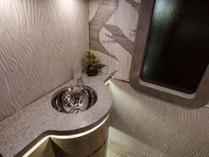 Quartz countertops adorn the bathroom in the rear of the portable home.