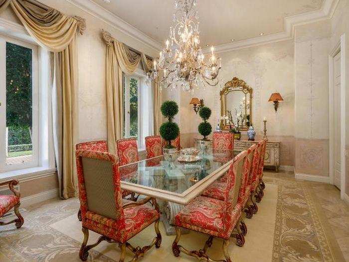 The formal dining room has a large chandelier and leads into the backyard.