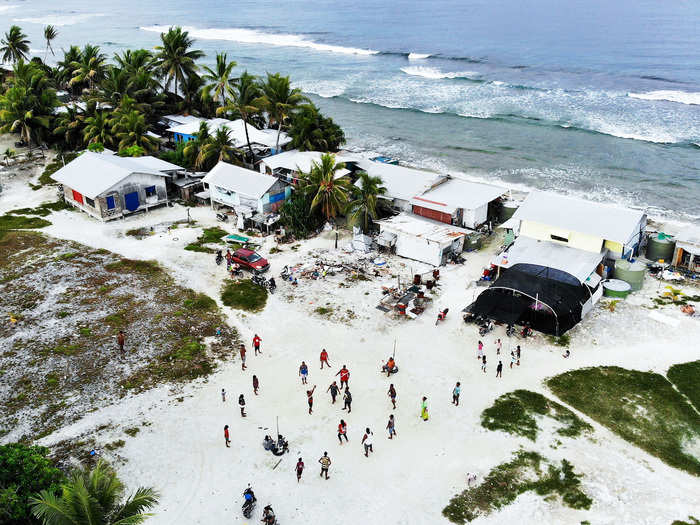 They play volleyball on the white sand.