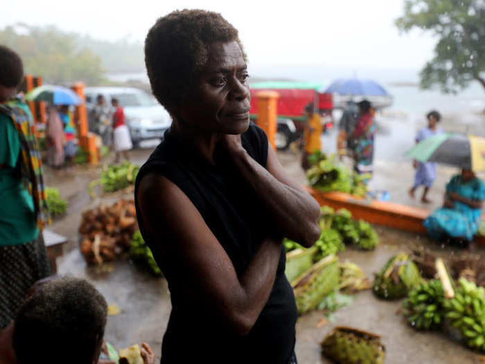 But farming is becoming increasingly difficult with droughts and salty soil. Here, a woman somberly watches the first significant amount of rainfall the country had in months, in December.