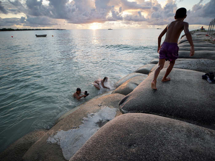 About 11,000 people live in Tuvalu. The island nation is 10 feet above sea level at its highest point and could be unlivable within 50 to 100 years. Children play on sandbags installed to slow the effects of rising seas.